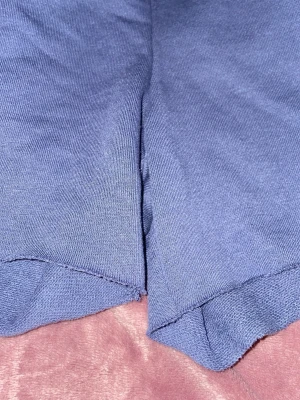 Blå shorts Athletics Club - Säljer ett par blå shorts med trycket 'M ATHLETICS CLUB' i rött och vitt på ena benet. Shortsen har en avslappnad passform och är gjorda i mjukt bomullsmaterial. Perfekta för chill dagar eller träning.mycket bra skick.