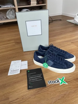 Tom Ford Cambridge  - Snygga marinblå sneakers från Tom Ford i mocka med vita sulor och diskret logga på hälen. Klassisk låg modell med matchande blå skosnören och stilren design. Perfekta för dig som gillar exklusiva och tidlösa sneakers.Obs de e f@k3