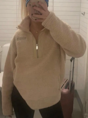 Beige teddytröja från norrsken  - Mysig beige teddytröja från norrsken med halv dragkedja framtill och hög krage. 