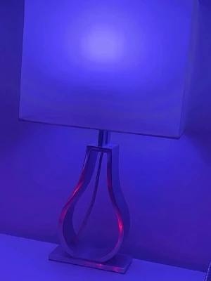 Modern bordslampa med fyrkantig skärm - Säljer en stilren bordslampa med vit fyrkantig lampskärm och en dekorativ metallfot i silverfärg. Lampfoten har en öppen, böjd design som ger ett modernt intryck. Perfekt som inredningsdetalj i sovrum eller vardagsrum.