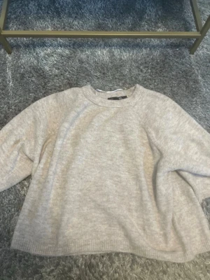 Beige oversized stickad tröja - Mysig beige stickad tröja med avslappnad, oversized passform och rund halsringning. Tröjan har ribbade muddar vid ärmslut och nederkant. Perfekt för lager på lager och en chill look.pris kan diskuteras 