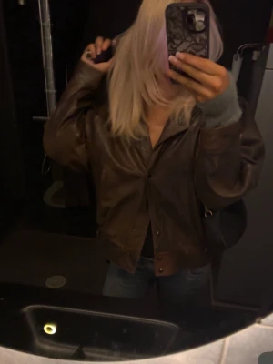 vintage oversize läderjacka - Säljer en brun läderjacka i oversize modell med bred krage och tryckknappar. Jackan har en cool retrovibe och är tillverkad i äkta läder med ljus insida. Perfekt för dig som vill ha en unik och tidlös look.