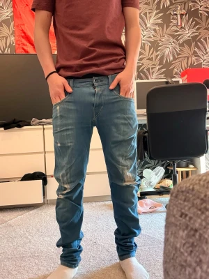 replay anbass jeans med sköna slitningar - Tja! Säljer ett par blå anbass jeans med snygga slitningar och tvättade detaljer på låren och knäna. Jeansen har klassisk femficksdesign och normal midja. Jag är 172. Jeansen är i storlek W28 L30