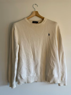 Polo Ralph Lauren Crewneck - Polo Ralph Lauren crewneck i cream, stl L. Tjockare stickad konstruktion, 100% bomull. Vintage gold-text label – äldre modell med mer karaktär. Skick väldigt bra