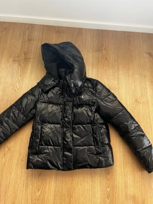 Svart pufferjacka från Calvin Klein - Snygg svart glansjacka från Calvin Klein 