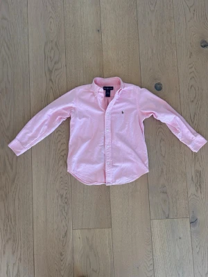 Rosa Ralph Lauren skjorta, 6 år - En nästintill ny rosa Ralph Lauren skjorta. Storleken är 6 år och passar för både tjejer och killar. Drömskick på skjortan för endast 149 kr! Kontakta vid minsta fundering! 😁