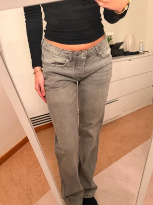Grå raka jeans från 157 - Säljer ett par grå lowwaist jeans från 157 med rak passform och klassisk femficksdesign. Jeansen har låg midja och är tillverkade i ett mjukt denimtyg som är skönt att bära. Perfekta för en avslappnad och trendig look.