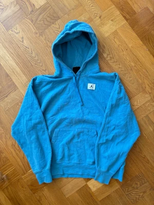 Blå Jordan hoodie vintage  - Snygg blå hoodie från Jordan med klassisk huva och magficka. Ikonisk Jumpman-logga på bröstet. Perfekt för en avslappnad streetwear-look. Mjuk bomullskänsla och ribbade muddar vid ärmslut och nederkant. Storlek S, fint skick! 