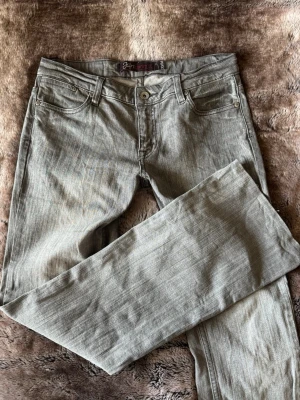 Grå utsvängda jeans från Fornarina - Snygga grå jeans från Fornarina med utsvängda ben och klassisk femficksmodell. Jeansen har diskreta sömmar och coola bakfickor med unik design. Tillverkade i mjukt denimtyg