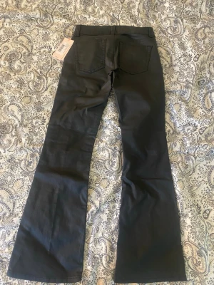 Coated Low Waist Jeans från Nelly - Coated Low Waist Jeans från Nelly, Storlek 36/Short, helt oanvända och säljer dom för att dom var för korta men det har gått för lång tid för att lämna tillbaka, priset kan diskuteras!