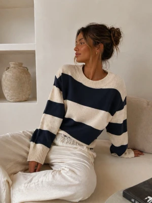Randig stickad tröja i blått och beige - Snygg stickad tröja med breda marinblå och beige ränder. Tröjan har rund halsringning, långa ärmar och ribbstickade muddar. Perfekt för en avslappnad och trendig look. Storlek M men passar mer S