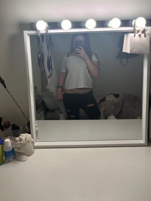 Vit crop top med slitsad rygg - Säljer en vit crop top med korta ärmar och en riktigt cool slitsad design i ryggen. T-shirten har en avslappnad passform och är gjord i mjukt bomullstyg. Perfekt för dig som vill sticka ut med en edgy och trendig look.