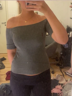 Grå off shoulder topp - Snygg grå off shoulder topp med tight passform och halvlånga ärmar. Ser nu att det är en fläck på bilden men det är enbart smuts på spegeln inte tröjan🤗skriv för fler bilder❤️