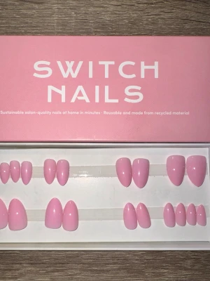 Switch Nails Flamingo Almond Short - Snygga press-on naglar från Switch Nails i modellen Flamingo. Naglarna har en kort mandelform och kommer i en mjuk rosa färg. Tillverkade av återvunnet material och kan återanvändas. Perfekt för dig som vill ha salongskänsla hemma på nolltid. Säljes utan tillbehör.