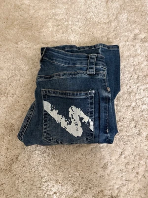 Lågmidjade jeans  - Mörkblå lågmidjade bootcut jeans från Nelly 