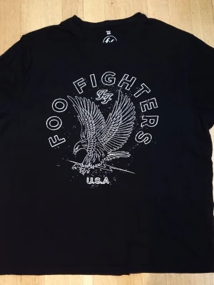 Foo Fighters T-Shirt | 3XL / XXXL - T-Shirt med Foo Fighters tryck på framsidan.  3XL / XXXL (Mått finns på bilderna!) 100% bomull.  Se bilder.