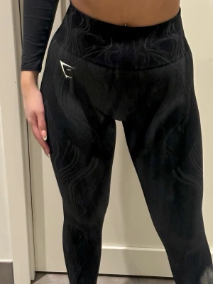 Nya Gymshark träningsbyxor – aldrig använda - Helt nya träningsbyxor, aldrig använda. Sitter riktigt snyggt på och är både bekväma och stretchiga. Perfekta för träning, gym, promenader eller som snygga vardagsbyxor.  Mjukt och följsamt material med bra passform som formar fint utan att kännas tight. Hög midja som sitter på plats. Ord pris: 599kr  - Pris kan diskuteras vid snabb affär  - Endast testade, inga slitage - Rökfritt hem - Skickas snabbt