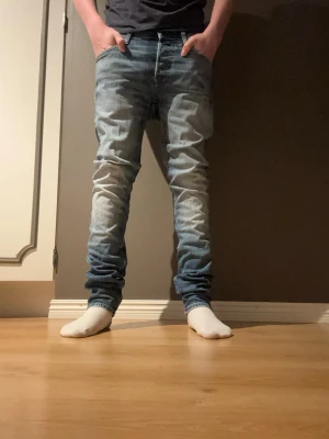 Jeans  - Säljer ett par blå slim fit jeans med snygga tvättade detaljer och lätt slitna partier framtill. Jack & Jones slim modell - storlek 29/32