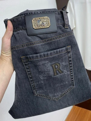 Grå raka jeans från Durkin - Snygga grå jeans från Durkin med raka ben och klassisk femficksmodell. Bakfickan har ett broderat R och ett coolt drakmotiv. Jeansen har en unik patch med metallogo i midjan och kontrastsömmar. Perfekta för en trendig och avslappnad stil.