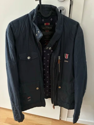 Mörkblå jacka från Morris - Snygg mörkblå jacka från Morris med ståkrage, dragkedja och knappar framtill. Bra skick storlek M. Passar höst/vår 