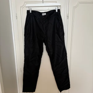 Svarta chinos från These Glory Days - Snygga svarta chinos från These Glory Days i klassisk rak modell. Perfekta för en clean och stilren look.