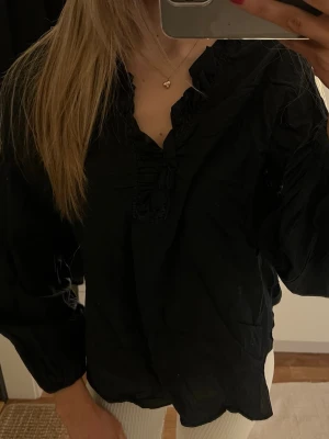 Svart blus  - En söt svart blus med volanger framtill🩷