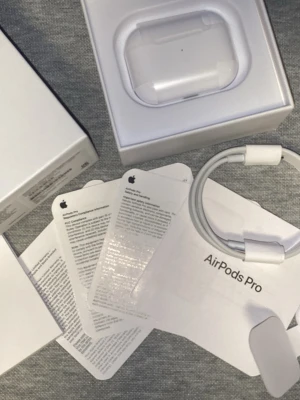 Apple AirPods Pro med laddningsetui - Säljer ett par vita Apple AirPods Pro med trådlöst laddningsetui. Hörlurarna har en stilren och kompakt design i blank plast och levereras med originalkartong, laddningskabel och manualer. Perfekta för dig som vill ha grymt ljud och brusreducering.