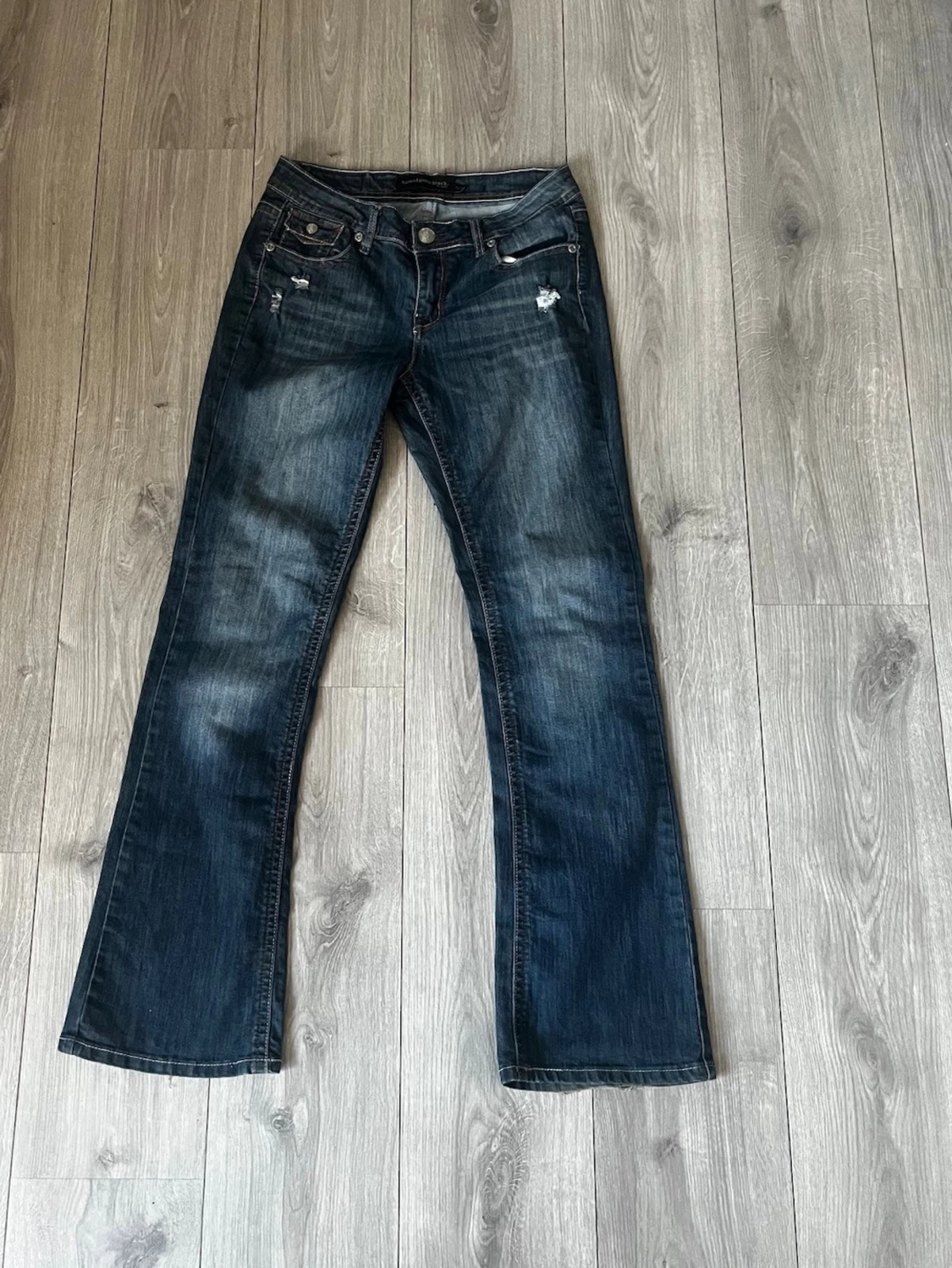 Mörkblå bootcut jeans lågmidjade med fickor