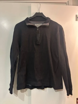 Svart halvzip tröja med krage - En svart långärmad tröja med halv dragkedja och hög krage från Calvin Klein.🌟