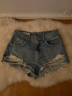 jeansshorts med fransar - Trendiga jeansshorts från ZARA med snygg slitning framtill och råa kanter nertill. Perfekt passform för sommaren och använd en gång, slitningarna är original💕  #zara #jeansshorts  #denimshorts  #sommarstil #highwaist  #vintagevibes  #casualstyle #vintedfinds   Storlek: EU 38 (står även USA 6)