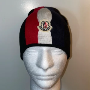 Moncler tricolour mössa, One size  - Helt ny. Fin replika med hög kvalitét. One size. Pris: 799kr. Först till kvarn. Skickas direkt inom 24h