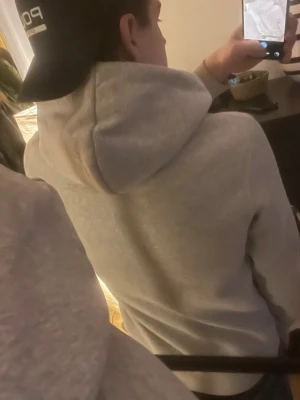 Grå hoodie från Polo Ralph Lauren - Säljer en grå hoodie från Polo Ralph Lauren med stor svart logga på bröstet. Hoodien har huva med vita snören och en klassisk magficka. Perfekt för en avslappnad och stilren look. Vid funderingar hör av er direkt!!!!