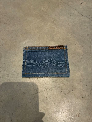 Jeansplånbok - Handsydd plånbok i vintage jeans. Varje exemplar är unikt med snygga detaljer. Plånboken håller flera kort utan att dem åker ut. Små variationer i färg och struktur visar på plaggets tidigare historia💙  Tiktok: Jeanius.bc 