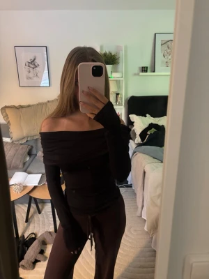 Svart offshoulder topp - Säljer en svart offshoulder topp med lång ärm och tight passform. Skit snygg till våren😍Aldrig använd!