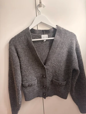 Stickad kofta - Säljer denna gråa stickade koftan från H&M med snygga detaljer❣️