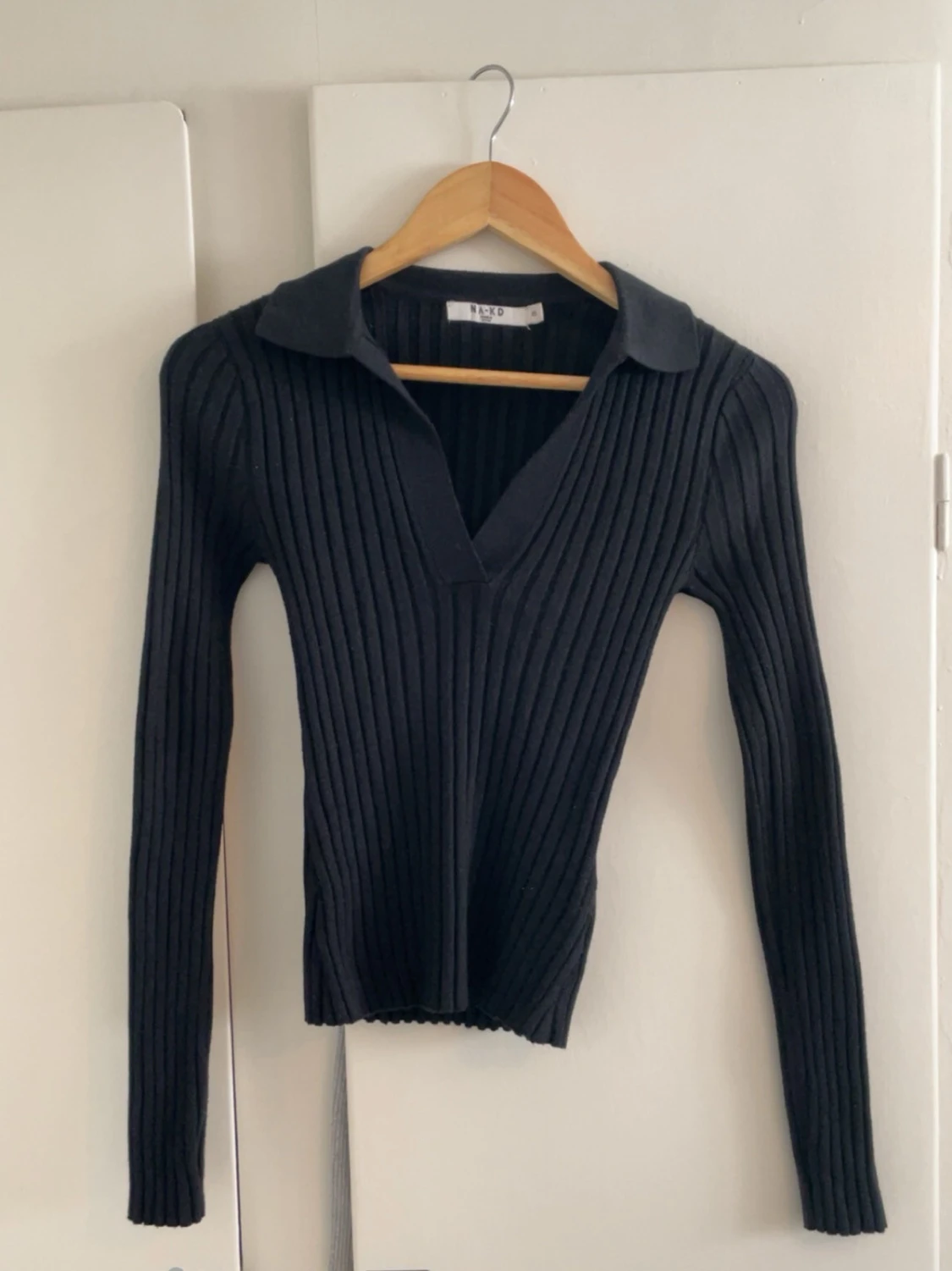 Svart ribbstickad tröja med krage