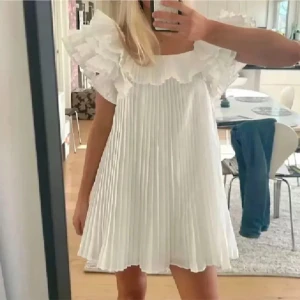 Vit plisserad klänning med volang - Superfin!!!💓💓💓Jätte eftertraktad klänning från Zara, aldrig använd med lappen kvar.🥰Storlek M men är som en S/xs