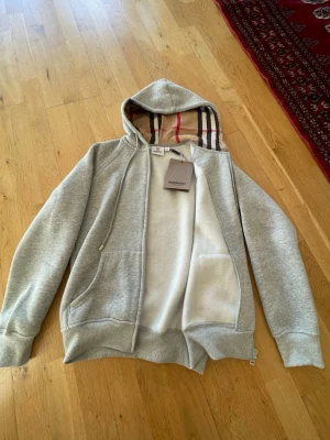 Grå hoodie  - Säljer en grå zip-hoodie. Storlek M    Men den  passar som XS