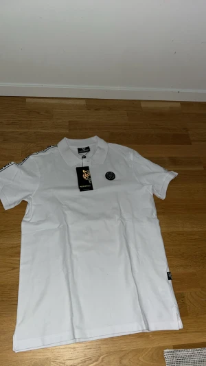 Vit piké från Philip Plein Sport - HELT oanvänd perfekt skick. vit pikétröja från Philip Plein Sport. Köpte den i somras men den passade mig inte och sen dess har den bara legat i min garderob. Priset är INTE hugget i sten. TAR BYTEN.