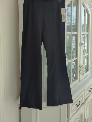 Svarta kostymbyxor från & Other Stories - Stilrena svarta kostymbyxor från Stories med vidare ben längst ned.. Byxorna har sytt pressveck och är tillverkade i ett mjukt, strechigt material som ger en snygg siluett. Helt nya. 
