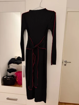 Svart klänning från ZARA - Svart ribbad midi/maxi klänning från Zara❤️Klänningen har ett knytband i midjan som ger en snygg siluett. I storlek M men passar även S!