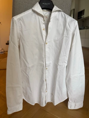 Vit skjorta från Tintoria Mattei - Klassisk vit skjorta från Tintoria Mattei med lång ärm och knäppning framtill.. Tillverkad i bomull för en skön och stilren look. Perfekt till jeans eller chinos.
