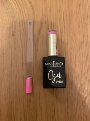 Miss Fancy Gel Polish Berry Sorbet - Miss Fancy Professional Gel Polish i färgen Berry Sorbet. Ett gelnagellack i en snygg, bärigt rosa nyans som ger en glansig finish. Kommer i en svart flaska med gulddetaljer och är perfekt för dig som vill ha hållbara och trendiga naglar.