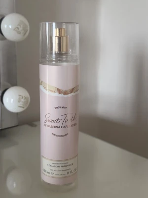 Sweet Tooth Body Mist från Sabrina Carpenter - Sweet Tooth Body Mist från Sabrina Carpenter har en ljusrosa, cylindrisk flaska med transparent lock och guldfärgad spraypump. Doften är söt med inslag av marshmallow, choklad och vanilj. Perfekt för dig som gillar gourmanddofter och vill ha något unikt. Nästan helt full! 💗