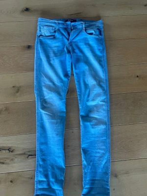 Ljusblå skinny jeans från Replay - Säljer ett par ljusblå skinny jeans från Dr. Denim med klassisk femficksdesign och läderpatch bak i midjan. Jeansen har smal passform och är tillverkade i stretchigt denimtyg för extra komfort. Perfekta för en avslappnad och trendig look.