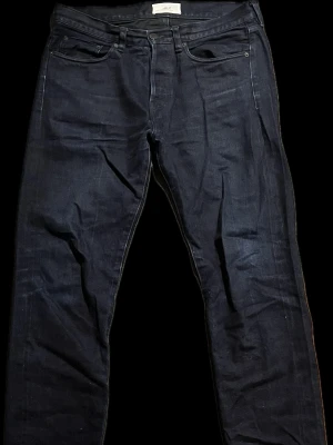 Mörkblå Mr.P selvedge jeans - Säljer ett par mörkblå jeans med rak passform. Jeansen är i japansk selvedge och är gjorda i Okayama i Japan. Jeansen har fått lite slitningar vid bland annat knäna. Nypriset ligger runt 2500kr. Pris går att diskutera!!! Mått: Midjan 44cm, ytter benlängd 104cm, benöppning 18cm. Måtten är inte exakta de kan vara +/- 1.