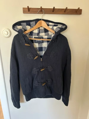 Mörkblå stickad hoodie med träknappar - Riktigt fet sällsynt stickad jacka/hoodie med rutigt foder. Köpt i Italien passar runt 173cm