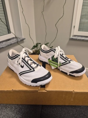 Nya vita Nike summer lite III golfskor med svarta detaljer 36.5 - Snygga vita golfskor från Nike med svarta detaljer och mesh-material för bra ventilation. Skorna har klassisk snörning och en robust sula med grepp, perfekt för sport och träning. Modern design med coola linjer längs sidan.
