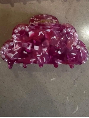 Rosa hårklämma med pärlor - Säljer en superfin hårklämma i rosa med vita detaljer/marmorerad och dekorerad med små pärlor längs kanterna. Klämman har en vågig form som ett moln. 89 kr!