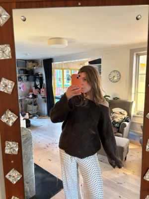 Mörkbrun oversized stickad tröja - Mysig mörkbrun stickad tröja med oversized passform och bred halsringning som kan bäras off-shoulder. Tröjan har långa ärmar och är tillverkad i ett mjukt, tjockt material som ger en avslappnad look.